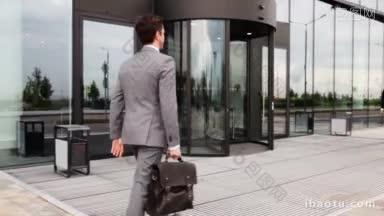 商务人士在办公大楼外握手，一起走进去